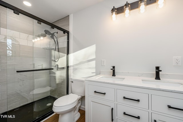 bathroom featuring toilet, vanity, and an enclosed shower