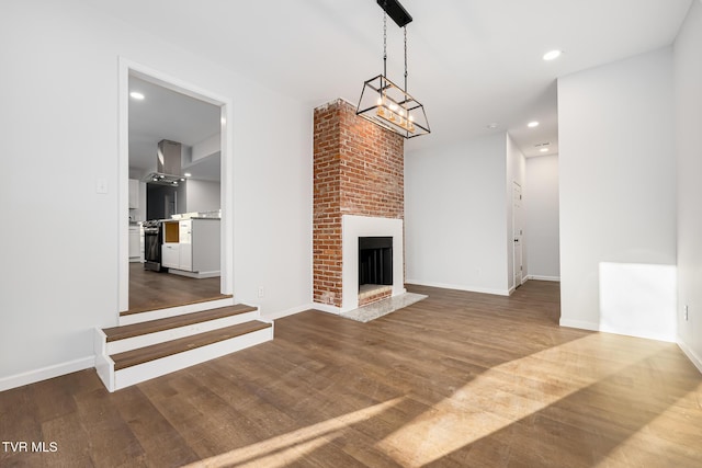 unfurnished living room featuring a brick fireplace and wood-type flooring