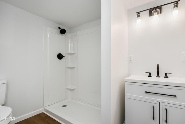 bathroom with a shower, hardwood / wood-style flooring, toilet, and vanity