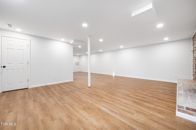 basement with light hardwood / wood-style floors