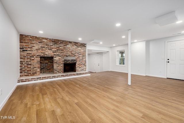 unfurnished living room with a fireplace and light hardwood / wood-style floors