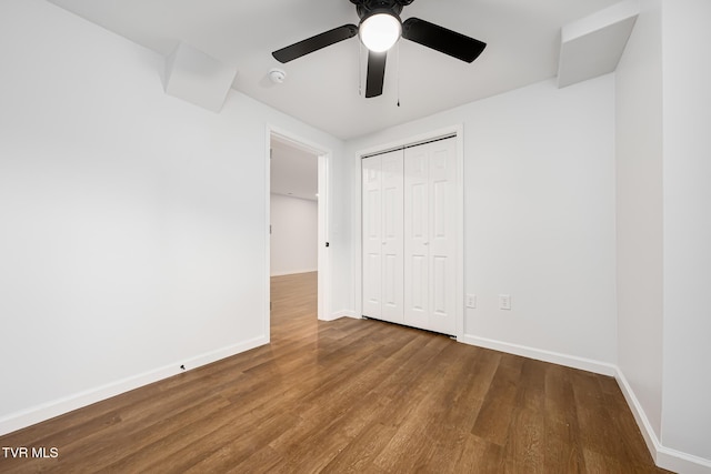 unfurnished bedroom with a closet, hardwood / wood-style flooring, and ceiling fan