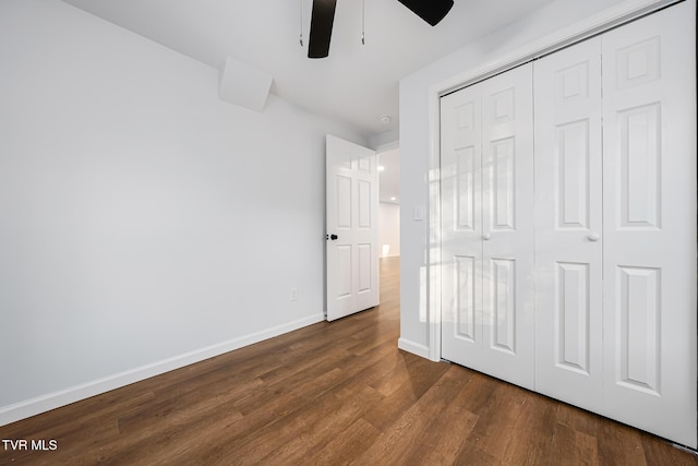 unfurnished bedroom featuring ceiling fan, a closet, and dark hardwood / wood-style flooring