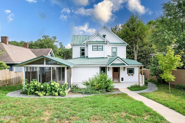 view of front of house featuring a sunroom and a front lawn