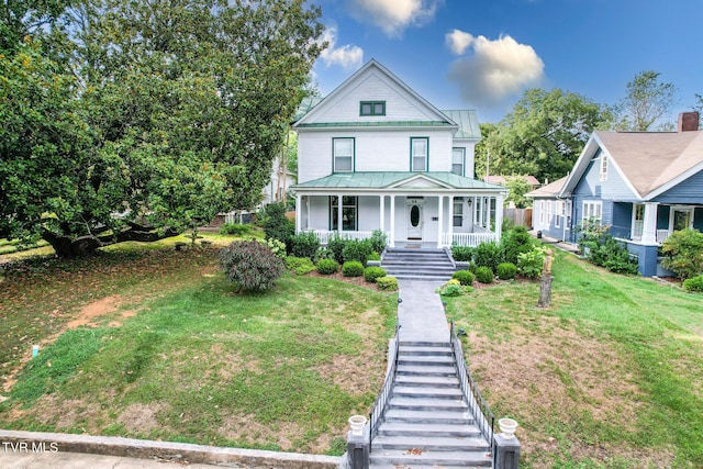 view of front of house with covered porch and a front lawn