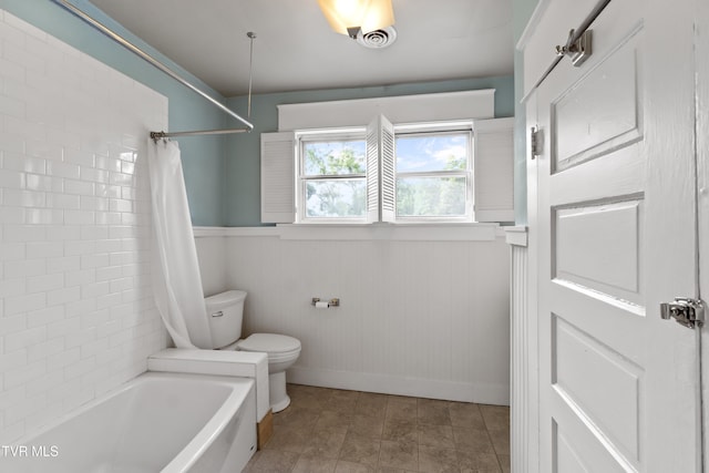 bathroom with toilet, wooden walls, and shower / bathtub combination with curtain