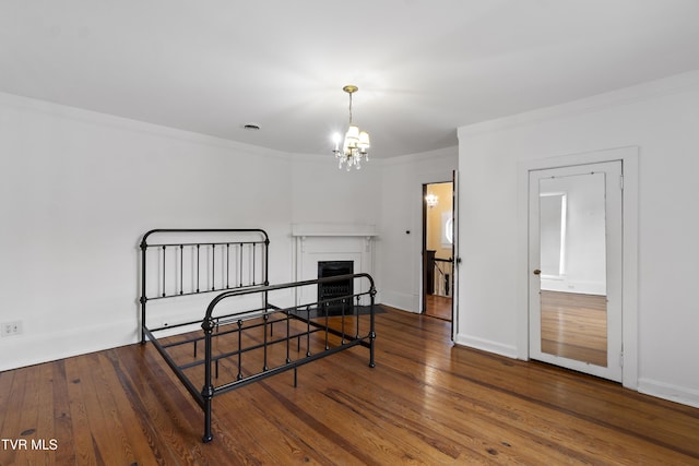 bedroom with a chandelier, hardwood / wood-style floors, and ornamental molding