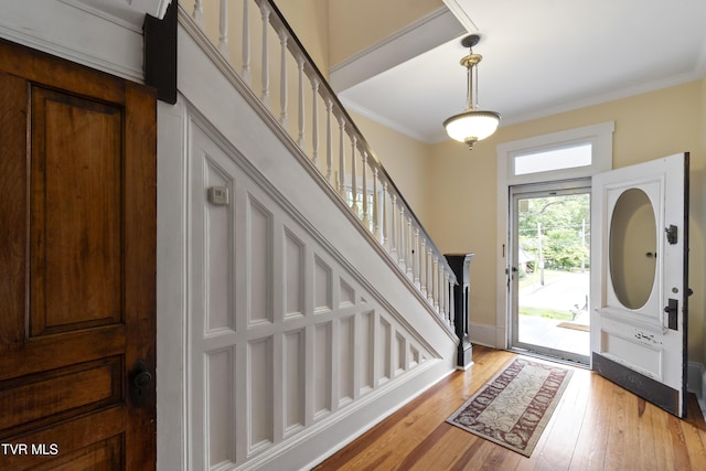 foyer entrance featuring ornamental molding and light hardwood / wood-style flooring