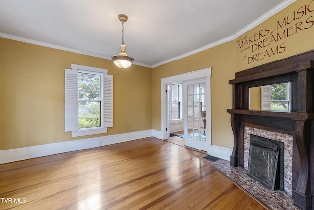 unfurnished living room with crown molding and hardwood / wood-style floors