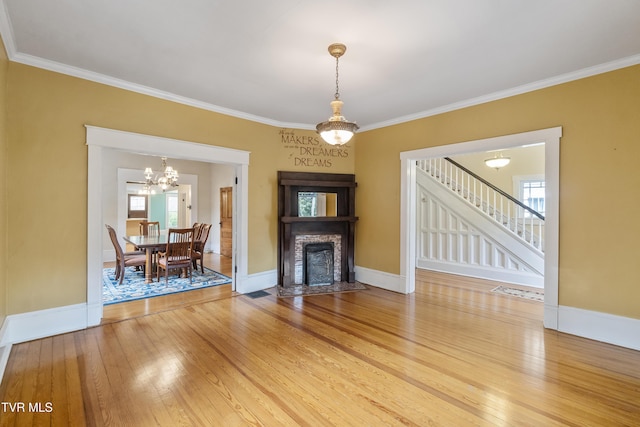 unfurnished living room featuring a notable chandelier, crown molding, and hardwood / wood-style floors