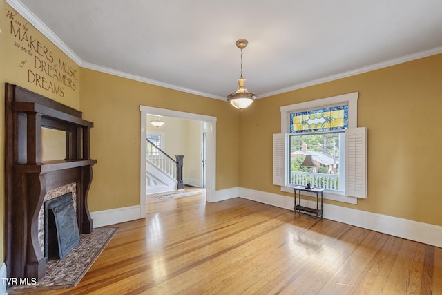 unfurnished living room featuring crown molding and hardwood / wood-style flooring