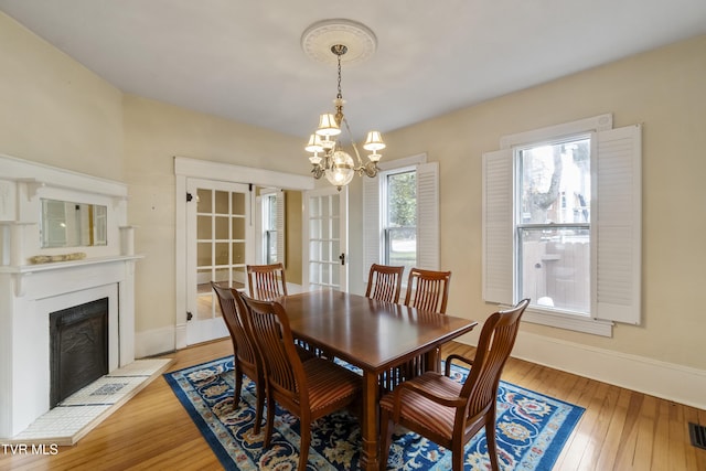 dining area with a notable chandelier and light hardwood / wood-style flooring