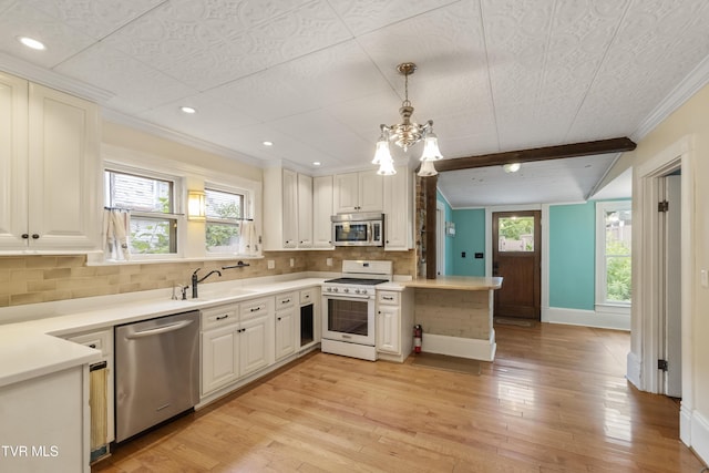 kitchen featuring sink, beamed ceiling, backsplash, hanging light fixtures, and appliances with stainless steel finishes