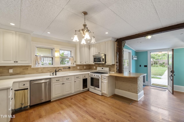 kitchen featuring tasteful backsplash, stainless steel appliances, kitchen peninsula, and pendant lighting