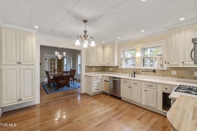 kitchen featuring appliances with stainless steel finishes, hanging light fixtures, and white cabinetry