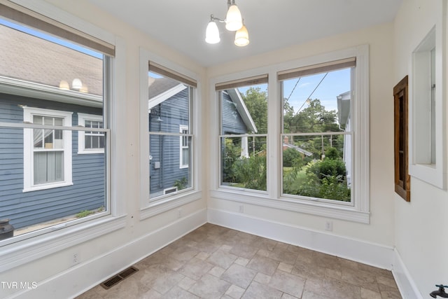 unfurnished sunroom with a notable chandelier