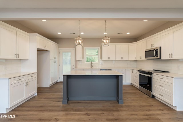 kitchen featuring stainless steel appliances, dark wood-style flooring, and white cabinetry