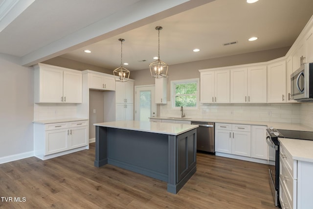 kitchen with a sink, stainless steel appliances, and white cabinetry