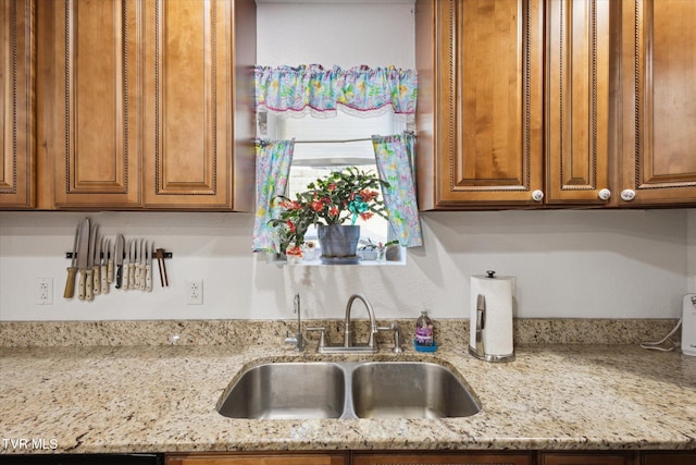 kitchen with light stone countertops and sink