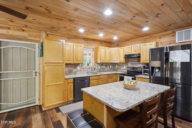 kitchen featuring sink, a breakfast bar, appliances with stainless steel finishes, range hood, and a center island