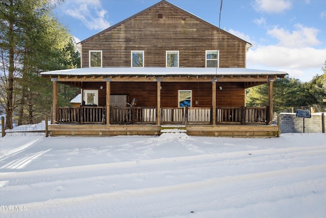 snow covered property with covered porch