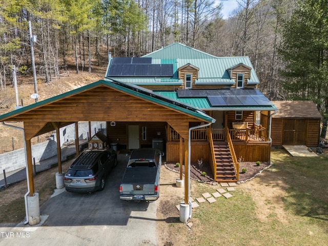 2191 Hubert Taylor Rd, Mountain City, TN 37683 - rustic home with aphalt driveway, roof mounted solar panels, metal roof, a storage shed, and an outdoor structure