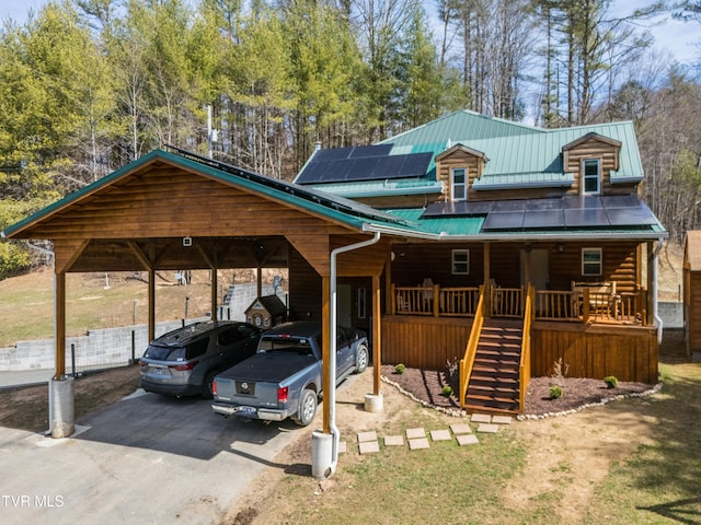 2191 Hubert Taylor Rd, Mountain City, TN 37683 - view of front facade with stairway, driveway, covered porch, roof mounted solar panels, and metal roof