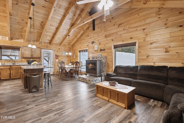 living room with beam ceiling, wooden ceiling, wood walls, and dark hardwood / wood-style floors