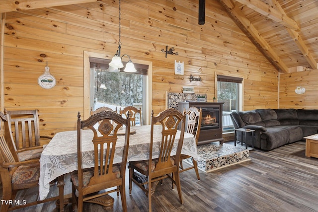 dining space with wooden walls, wood ceiling, an inviting chandelier, beam ceiling, and plenty of natural light