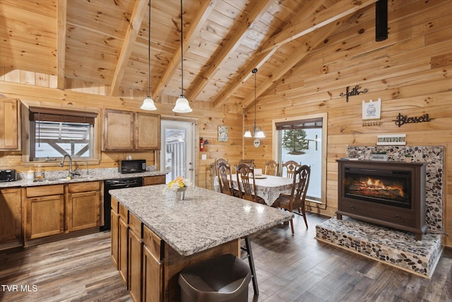 kitchen featuring hanging light fixtures, a kitchen island, beamed ceiling, wooden ceiling, and sink