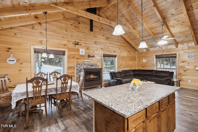 kitchen with decorative light fixtures, wooden walls, wood ceiling, and beamed ceiling