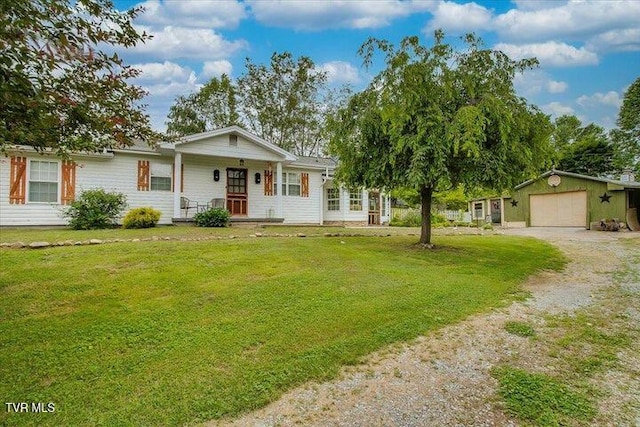 single story home with a porch, an outbuilding, a front yard, and a garage