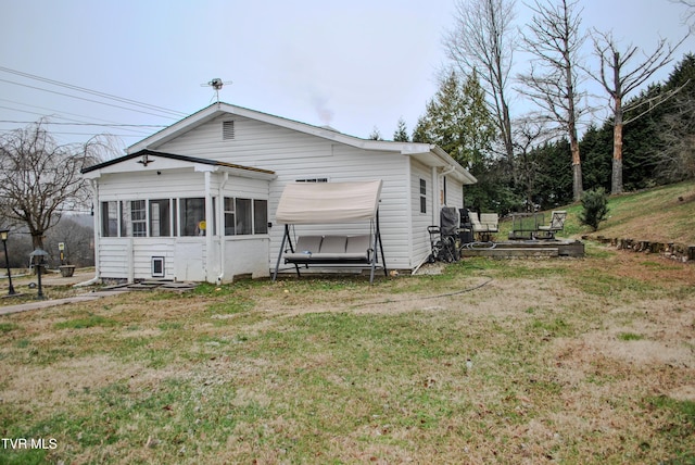 rear view of house with a yard and a sunroom