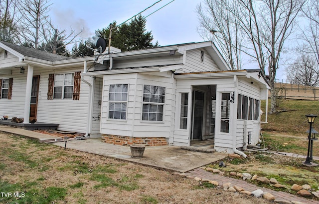 view of front of home featuring a sunroom and a patio area