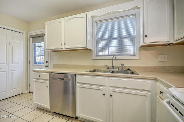 kitchen with dishwasher, a wealth of natural light, white cabinets, light tile patterned flooring, and sink