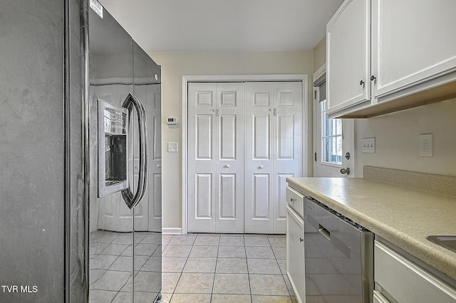 kitchen featuring dishwasher, light tile patterned floors, and white cabinetry