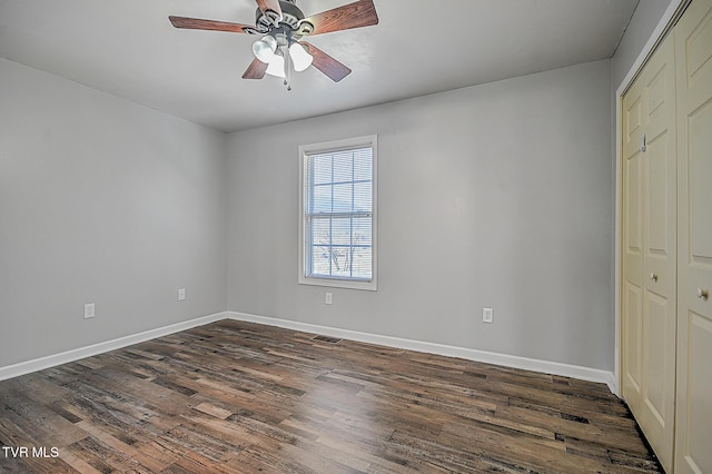 unfurnished bedroom featuring ceiling fan, dark hardwood / wood-style flooring, and a closet