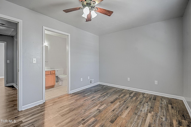 unfurnished bedroom with ensuite bathroom, ceiling fan, and light hardwood / wood-style floors