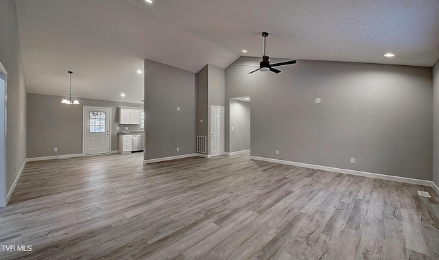 unfurnished living room featuring ceiling fan with notable chandelier, high vaulted ceiling, a textured ceiling, and light hardwood / wood-style flooring