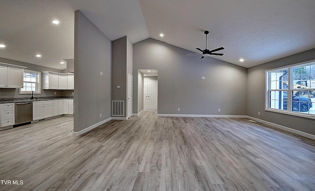 unfurnished living room featuring high vaulted ceiling, ceiling fan, and light hardwood / wood-style flooring