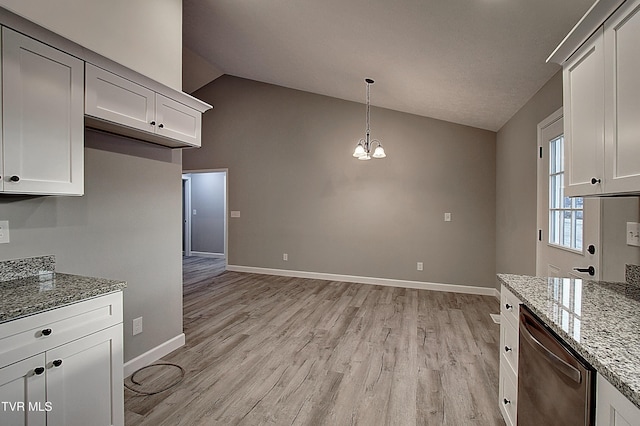 kitchen with a chandelier, light stone countertops, white cabinets, stainless steel dishwasher, and lofted ceiling