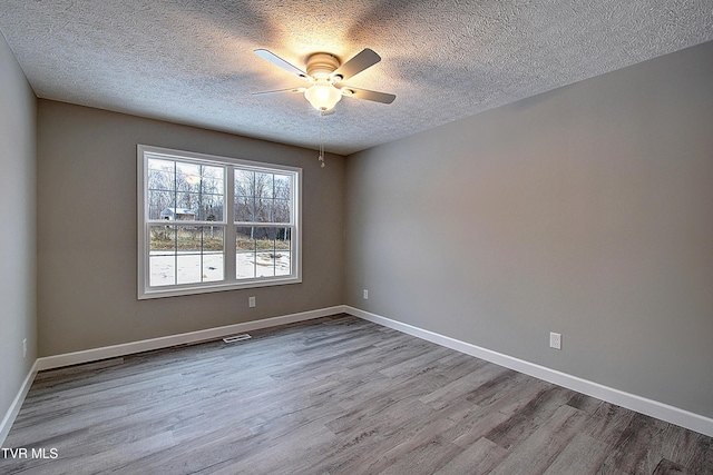 unfurnished room with a textured ceiling, ceiling fan, and light hardwood / wood-style flooring