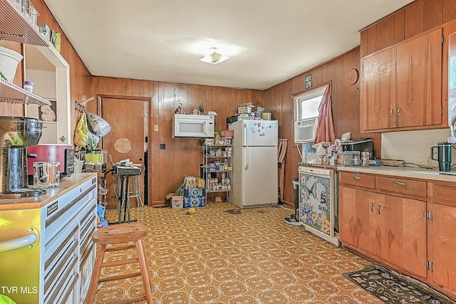 kitchen with a breakfast bar, white appliances, wood walls, and cooling unit