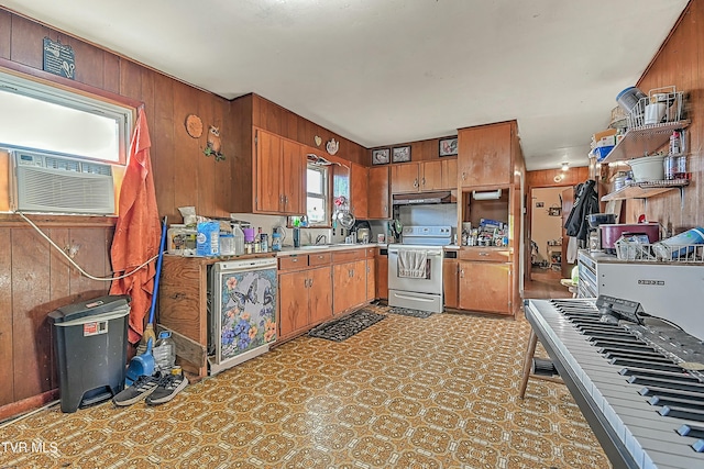 kitchen with dishwashing machine, white electric stove, and wood walls