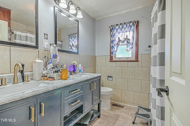 bathroom featuring tile walls, toilet, and vanity