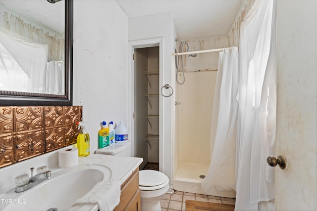 bathroom with toilet, a shower with shower curtain, vanity, and tile patterned floors