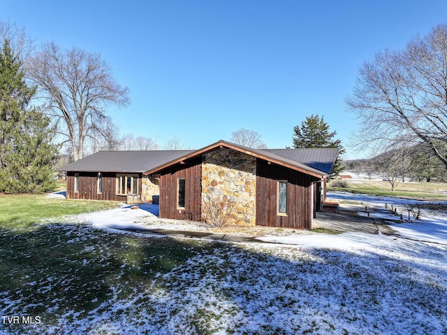 view of snow covered exterior with a lawn