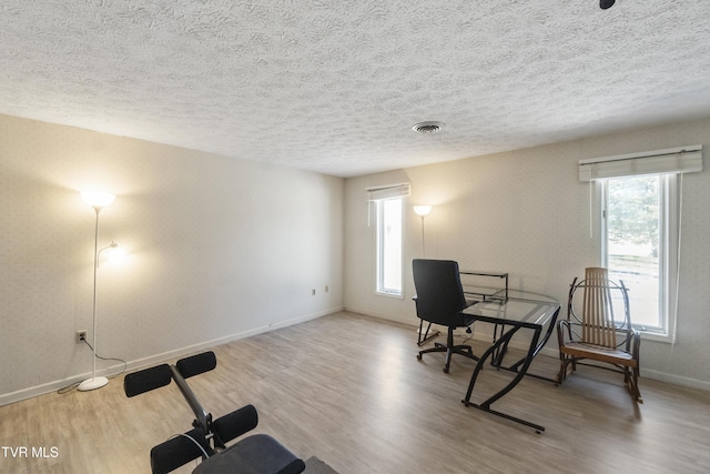 home office featuring a textured ceiling and light wood-type flooring