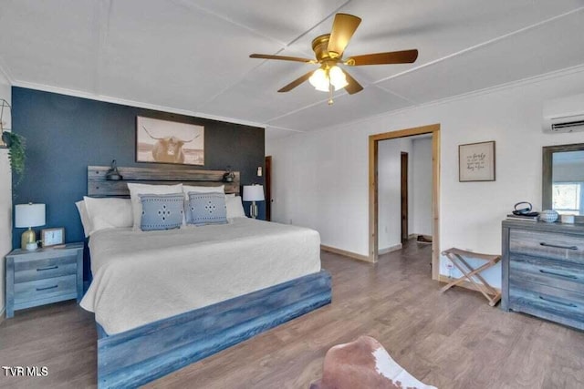 bedroom with ceiling fan, a wall mounted air conditioner, crown molding, and wood-type flooring