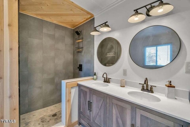 bathroom featuring tiled shower, wooden ceiling, and vanity